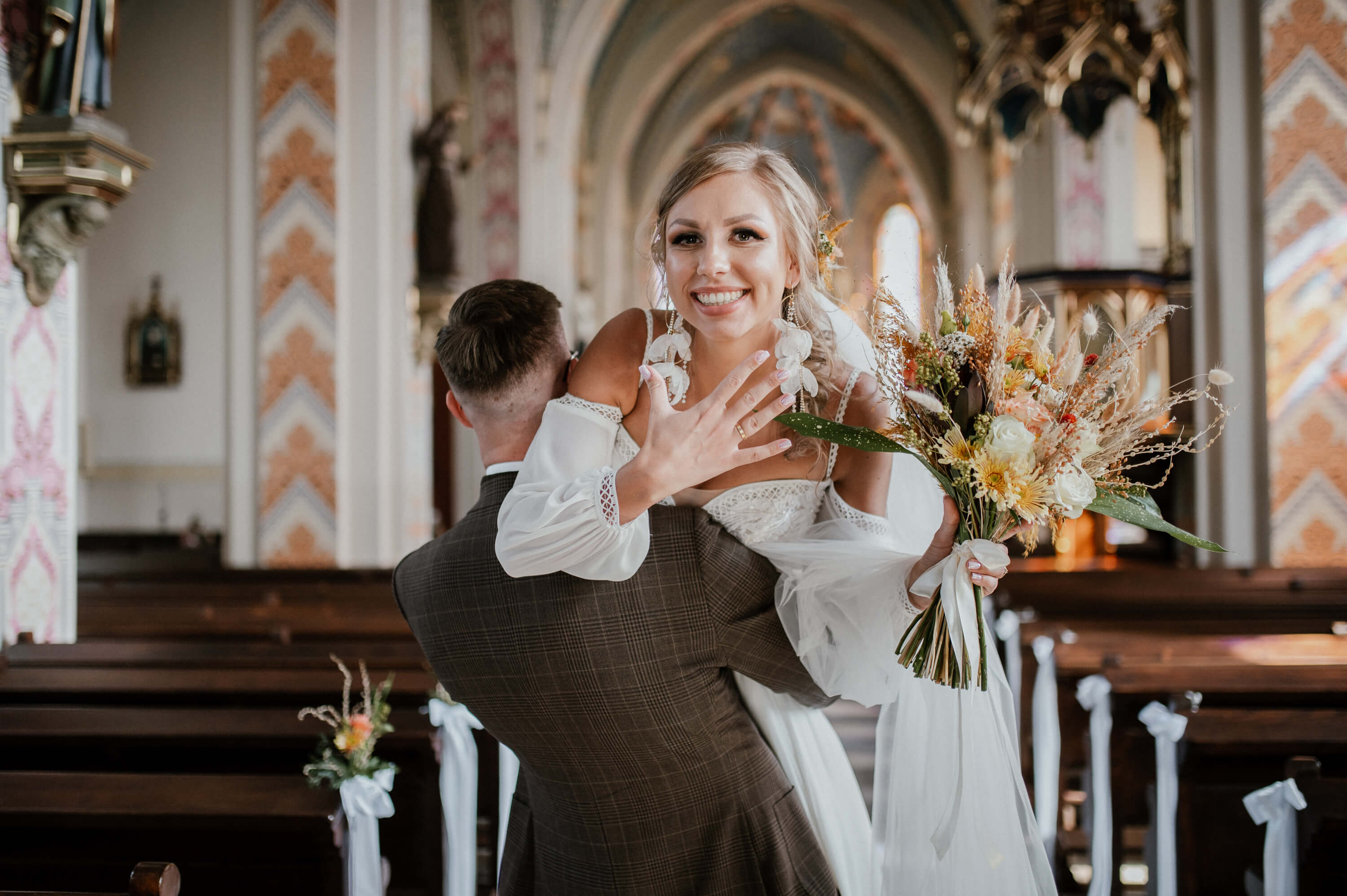 Zdjecie przedstawiające kobiete w ciąży stojąca latem wsród zboż